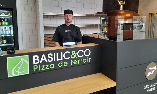 Alexandre Bertaux franchisé de Caen derrière son comptoir à l'ouverture de son restaurant.
