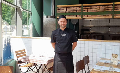 Fabien Monnier multi franchisé debout en tenue devant le comptoir de son restaurant Basilic & Co Montpellier